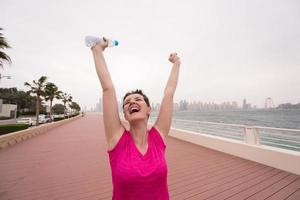 jovem comemorando uma corrida de treinamento bem sucedida foto