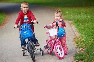 menino e menina com bicicleta foto