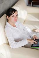 mulher usando tablet pc em casa foto