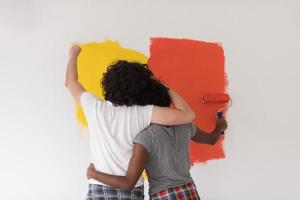 casal multiétnico pintando parede interior foto