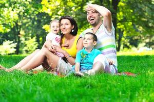 casal jovem feliz com seus filhos se divertir no parque foto