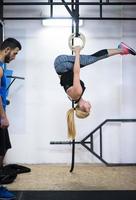 mulher malhando com personal trainer em anéis de ginástica foto