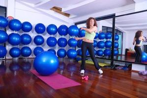 jovem mulher bonita se exercitando em um centro de fitness foto