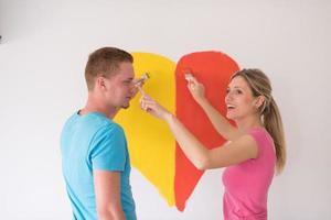 casal está pintando um coração na parede foto