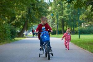 menino e menina com bicicleta foto