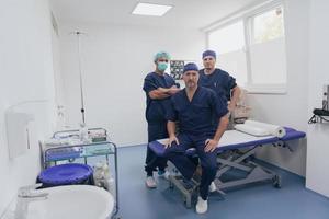 médico ortopedista multiétnico na frente de sua equipe médica olhando para câmera usando máscara facial foto