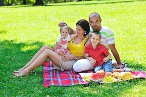 casal jovem feliz com seus filhos se divertir no parque foto