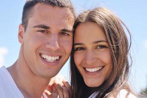 casal feliz se diverte na praia foto