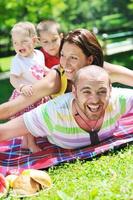 casal jovem feliz com seus filhos se divertir no parque foto