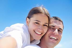 casal feliz se diverte na praia foto