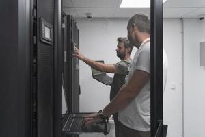 equipe de técnicos atualizando hardware inspecionando o desempenho do sistema na sala do supercomputador ou fazenda de mineração de criptomoedas. foto