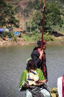 dieng, indonésia - 1 de agosto de 2015. festival de cultura de dieng, turistas seguem a procissão de dreadlocks durante o evento do festival de cultura de dieng em dieng, distrito de banjarnegara, java central foto