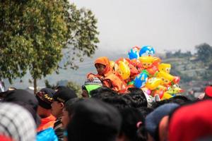 dieng, indonésia - 1 de agosto de 2015. festival de cultura de dieng, turistas seguem a procissão de dreadlocks durante o evento do festival de cultura de dieng em dieng, distrito de banjarnegara, java central foto