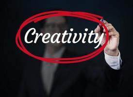 mão de empresário escrevendo criatividade com marcador vermelho na placa transparente, novo conceito de negócio, tiro de estúdio foto