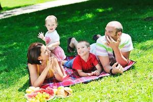 casal jovem feliz com seus filhos se divertir no parque foto