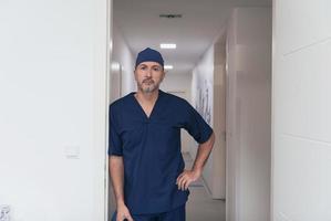 retrato de médico masculino maduro no corredor do hospital moderno ocupado. foto