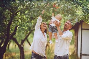 famílias com uma criança no jardim de verão foto