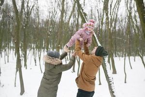 pai e mãe com uma filha no parque foto