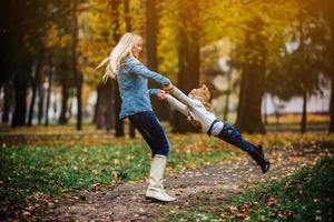 mãe com filha no parque outono foto