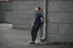 o homem com botas autênticas e jeans selvedge em um fundo da cidade velha foto