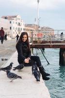 menina sentada na beira do grande canal foto