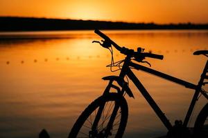 bicicleta no fundo de um pôr do sol foto