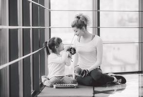 mãe e filha brincando com brinquedos no ginásio foto