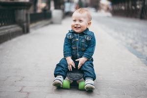 menino engraçado com skate na rua foto