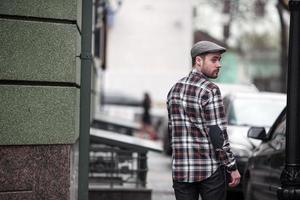 o homem com botas autênticas e jeans selvedge em um fundo da cidade velha foto