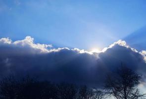 bela vista em raios de sol com alguns reflexos de lente e nuvens em um céu azul foto