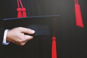 graduação, aluno segura chapéus na mão durante o sucesso de formatura graduados da universidade, foto