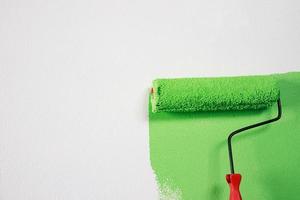 pintura de pincel de rolo, pintura de trabalhador em apartamento de pintura de parede de superfície, renovando com tinta de cor verde. foto