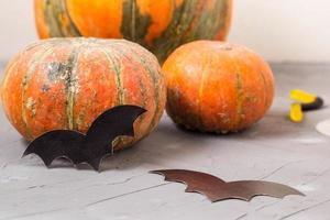 abóbora laranja e morcegos de papel na mesa branca, conceito de halloween foto