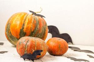 abóbora laranja e morcegos de papel na mesa branca, conceito de halloween foto