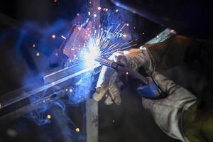 soldagem de metais. fogo da operação da máquina de solda. fabricação de costura de aço. processamento de perfil de aço. faíscas da soldagem. foto