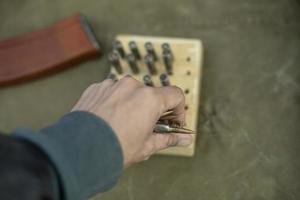 a mão pega a munição. cartuchos de armas de fogo automáticas. foto