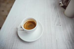 xícara de cappuccino na mesa de madeira branca. foto