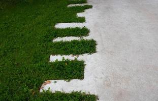 gramado verde e caminho em ziguezague de concreto no parque foto