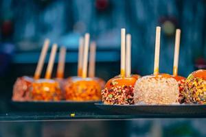 maçãs em caramelo e granulado. comida de rua. foto