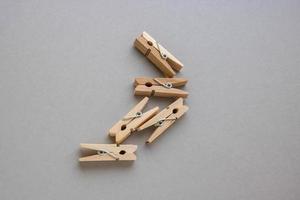 conjunto de pequenos prendedores de roupa de madeira para decoração em um fundo cinza foto