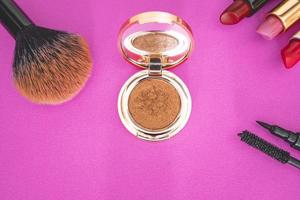 flatlay de maquiagem e produtos de beleza em um fundo rosa. foto