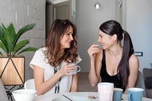 duas amigas tomando café da manhã na cozinha foto