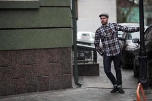 o homem com botas autênticas e jeans selvedge em um fundo da cidade velha foto