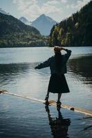 a garota de vestido e chapéu do lago nas montanhas foto
