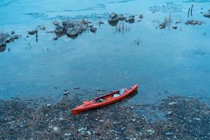 caiaque encontra-se em uma praia selvagem de um lago selvagem foto