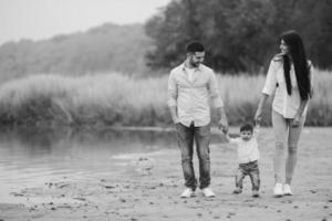 jovem família caminhando na praia foto