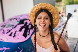 mulher com mangueira fica perto do carro coberto de espuma rosa foto