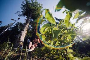 lindo casal sentado em uma floresta perto da árvore foto