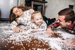 família feliz jogando juntos no chão foto