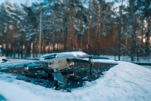 drone em pé no telhado de um carro coberto de neve foto